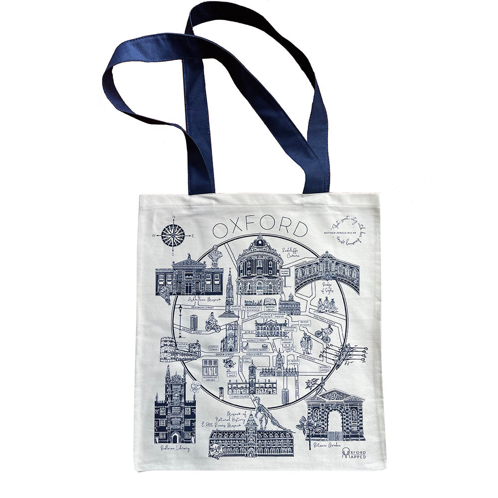 A tote bag featuring a hand-drawn map of Oxford, printed in blue on a white background, with handles and a quote by Oscar Wilde along the bottom.