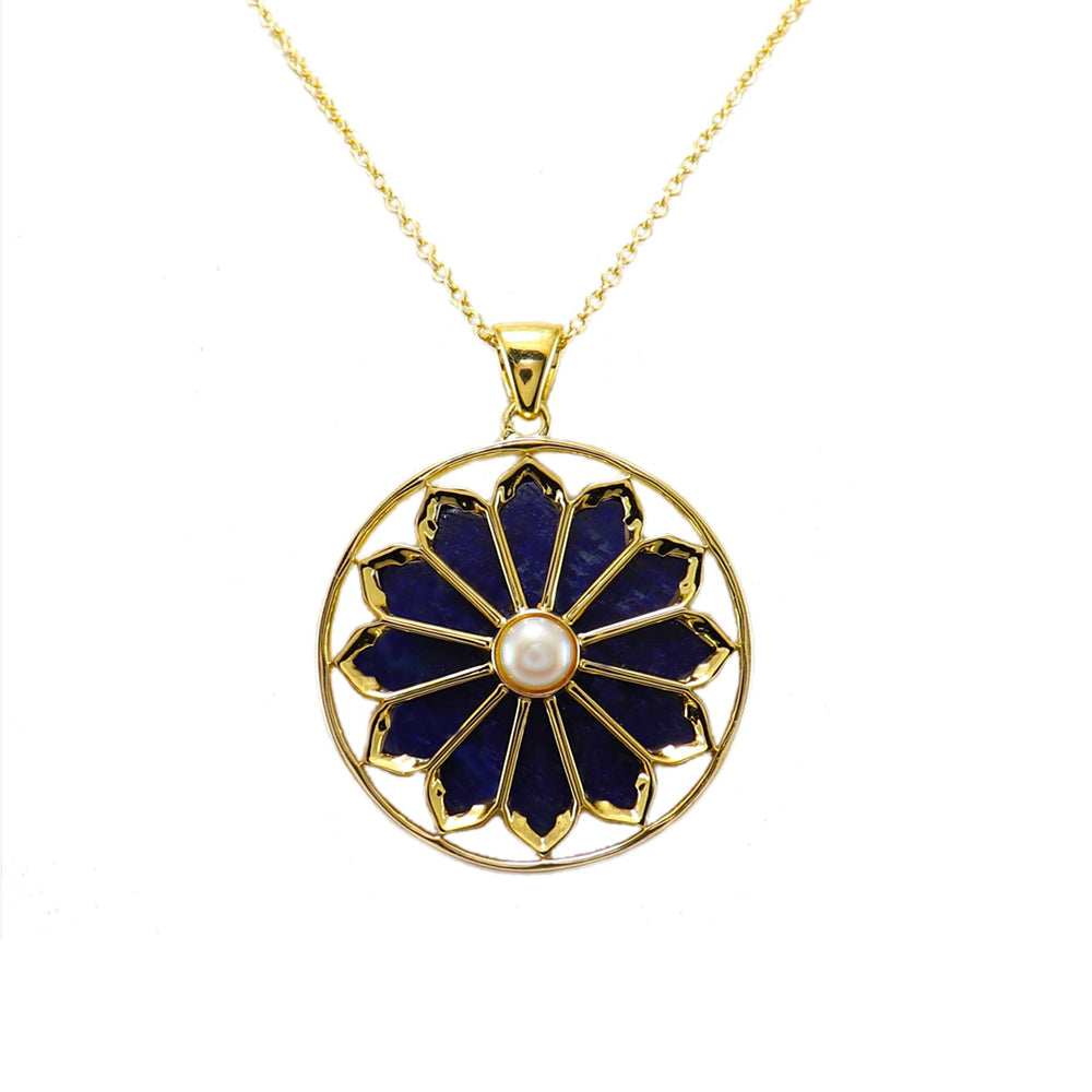 A gold plated necklace with a floral pendant featuring lapis and a pearl.