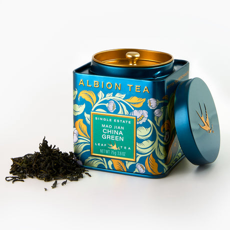 Albion Tea tin with floral design and tea leaves on a white background