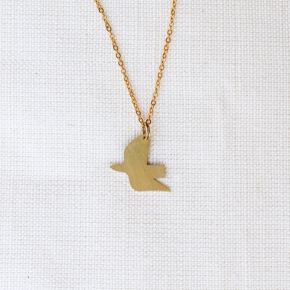 Gold bird-shaped pendant necklace on a white background