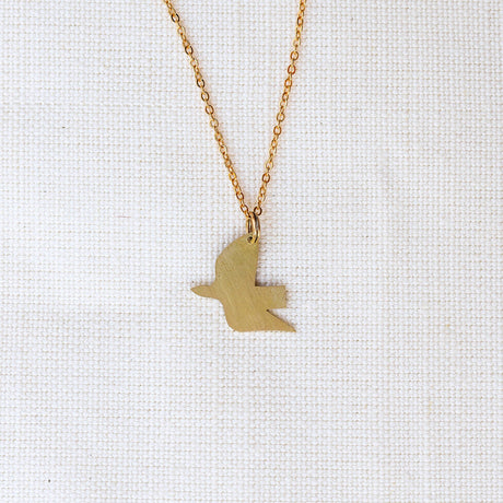 Gold bird-shaped pendant necklace on a white background