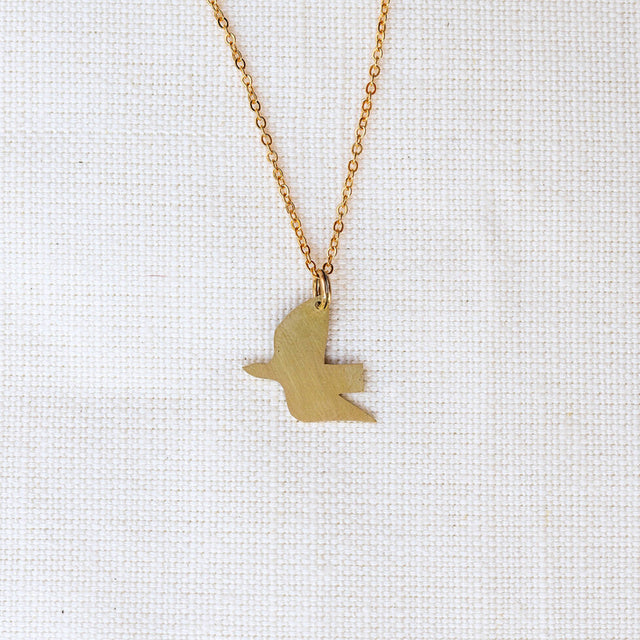 Gold bird-shaped pendant necklace on a white background