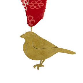 Gold bird ornament with a red ribbon on a white background