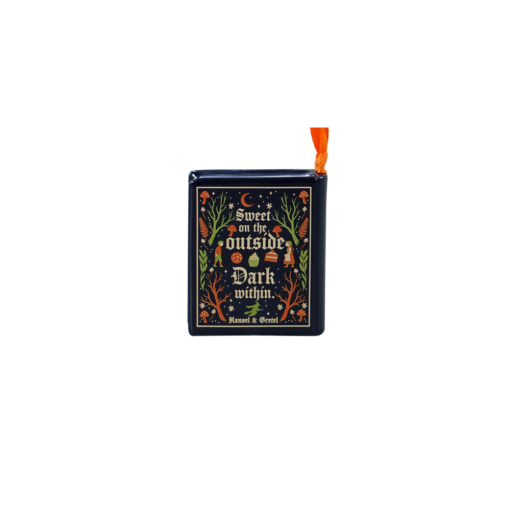 A small decorative book-shaped ornament with a dark navy cover featuring the phrase 'Sweet on the outside, Dark within.' in ornate floral and celestial artwork, with an orange ribbon loop at the top, shown on a plain white background.