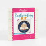 Outer box showcasing embroidery hoop with a design of  the Radcliffe Camera Library inside an open book against a night sky.