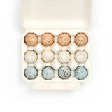 Egg carton with speckled eggs on a white background