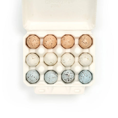 Egg carton with speckled eggs on a white background